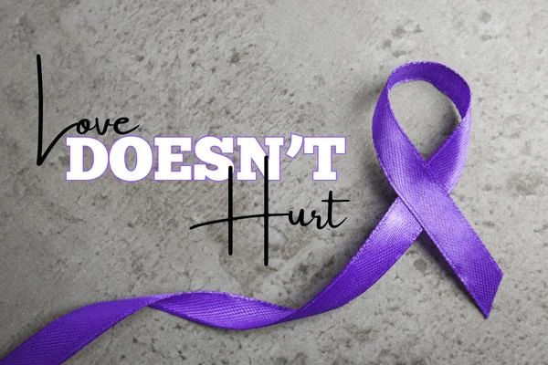Purple ribbon beside the words Love Doesn't Hurt
